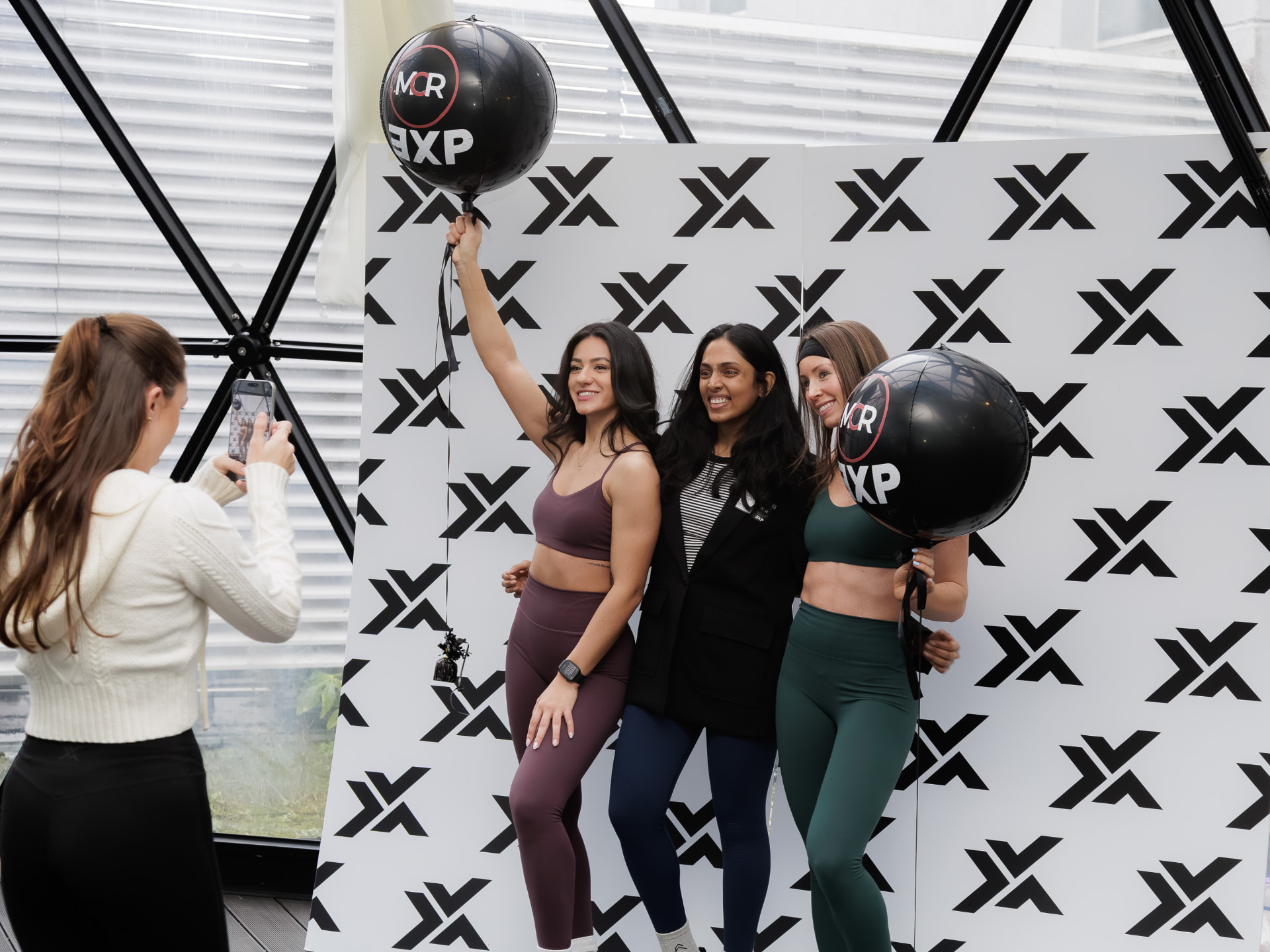 Attendees at the MCR EXP branded backdrop